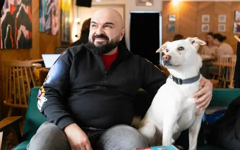 Mężczyzna z psem na kanapie. Czy psy myślą? Ten pies na pewno coś kombinuje, patrząc na niego.