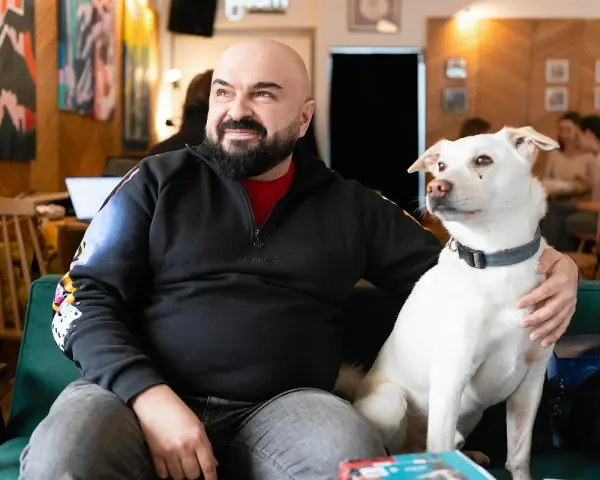 Mężczyzna z psem na kanapie. Czy psy myślą? Ten pies na pewno coś kombinuje, patrząc na niego.