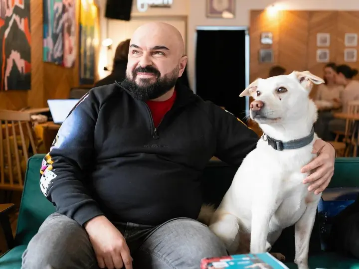 Mężczyzna z psem na kanapie. Czy psy myślą? Ten pies na pewno coś kombinuje, patrząc na niego.